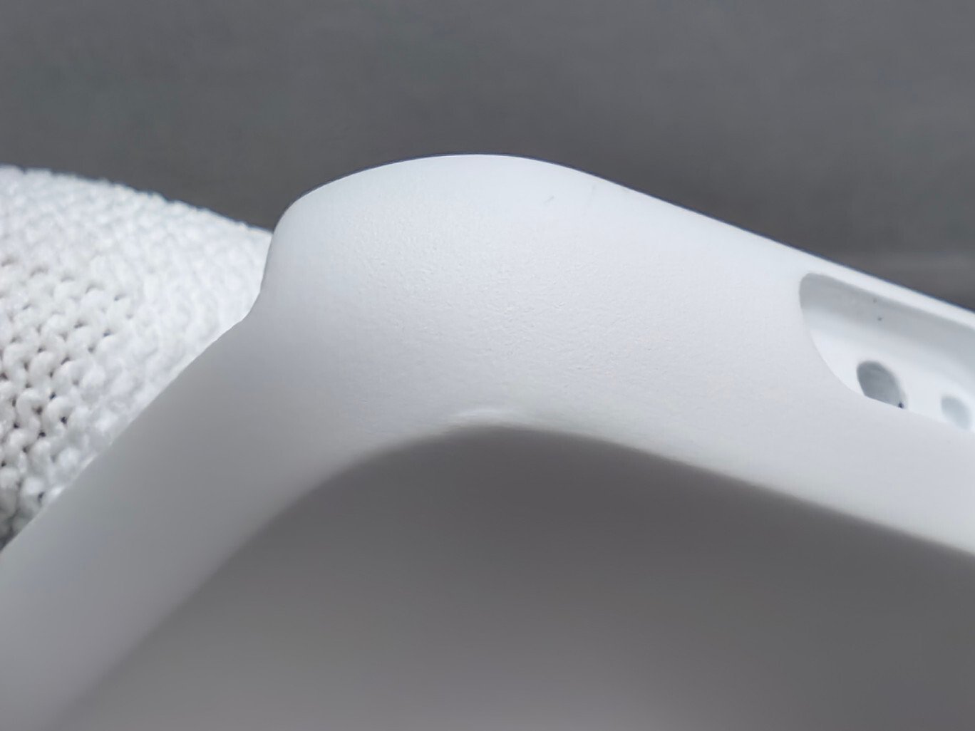 Close-up of material buildup along an edge of a white wearable housing during pilot inspection